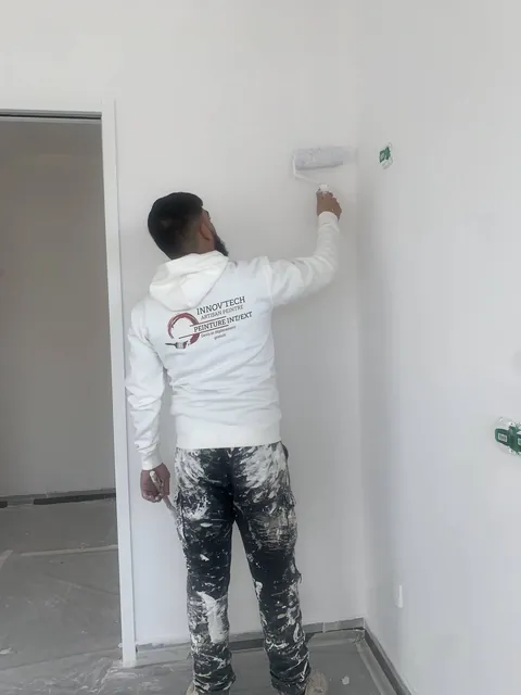 Peintre INNOV'TECH 66 en plein travail au rouleau sur un chantier neuf